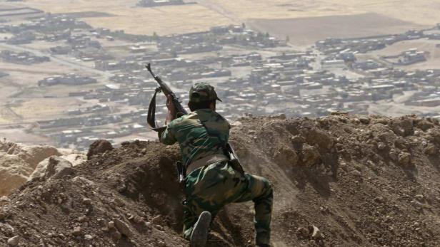 Ein kurdischer Peschmerga-Kämpfer beobachtet ein von den IS-Milizen besetztes nordirakisches Dorf.