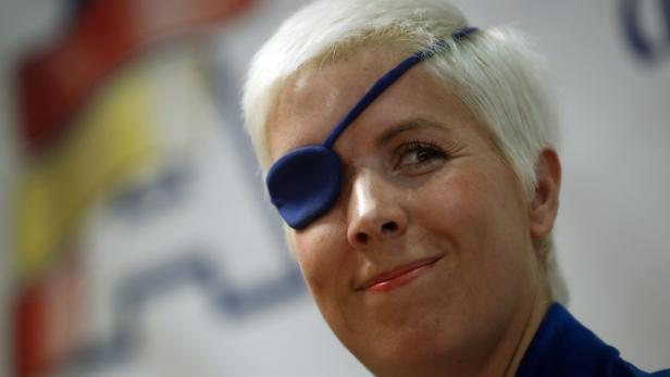 Eine Frau mit einem blauen Augenschutz lächelt.
