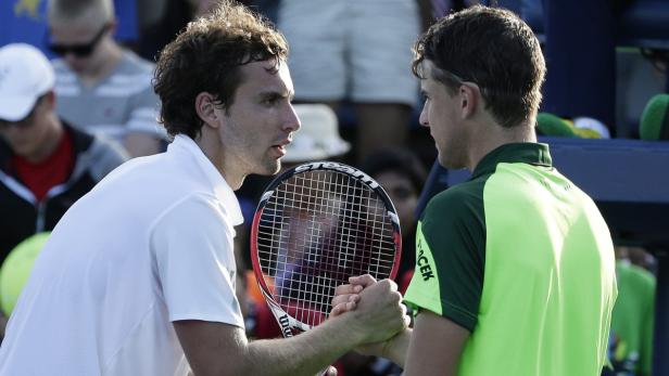 Zwei Tennisspieler schütteln sich nach einem Match die Hände.