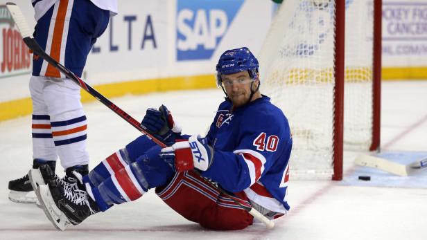 Ein Eishockeyspieler der New York Rangers sitzt auf dem Eis.