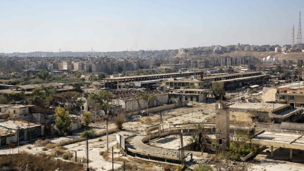 Eine zerstörte Stadtlandschaft mit beschädigten Gebäuden und einer Moschee im Vordergrund.