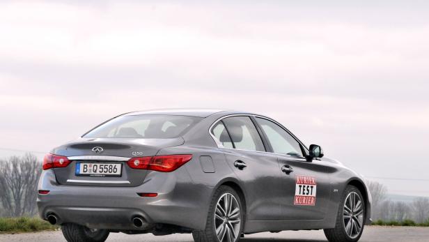 Ein grauer Infiniti Q50 mit Berliner Kennzeichen steht auf einer Straße.