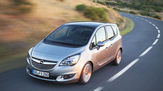 Ein silberner Opel Meriva fährt auf einer kurvenreichen Straße.