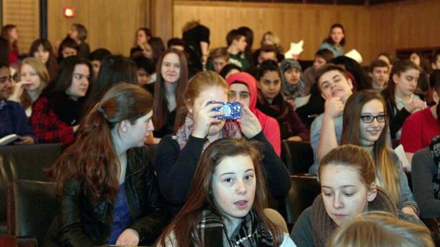 Eine Gruppe von Jugendlichen sitzt in einem Auditorium.