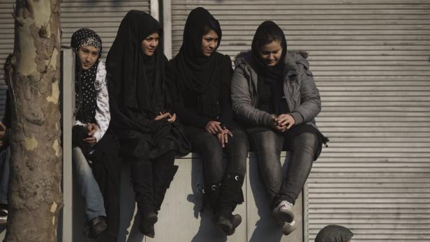 EDITORS&#039; NOTE: Reuters and other foreign media are subject to Iranian restrictions on leaving the office to report, film or take pictures in Tehran. Iranian Shi&#039;ite Muslim women sit top of an electric box case as they attend a religious festival marking Ashura on day eight of Muslim holy month of Moharram, near of Tehran&#039;s grand bazaar (Market) December 6, 2011. Ashura is the most important day in the Shi&#039;ite calendar, which commemorates the death of Imam Hussein, grandson of the Prophet Mohammad, in the 7th century battle of Kerbala. REUTERS/Morteza Nikoubazl (IRAN - Tags: RELIGION)