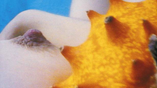 Eine Frau liegt neben einer Kiwano-Frucht.