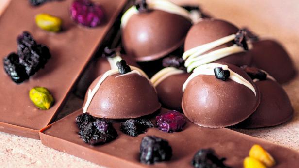 Schokoladentrüffel und Schokoladentafeln mit Trockenfrüchten und Pistazien.