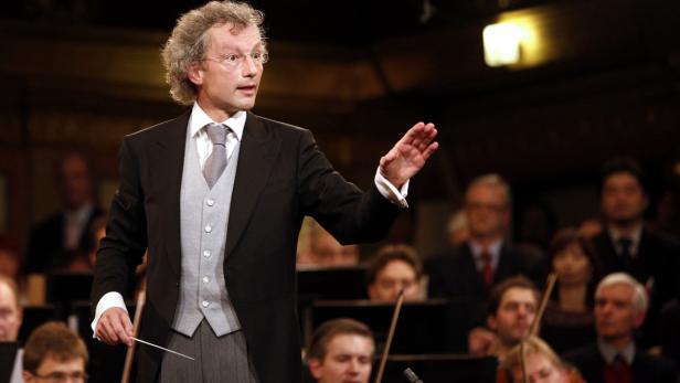 Ein Dirigent leitet ein Orchester mit seinem Taktstock.