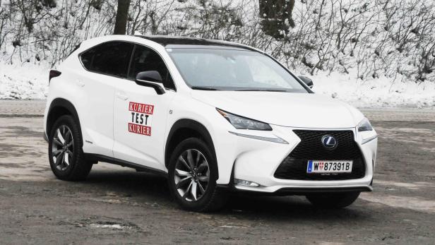 Ein weißer Lexus NX steht im Winter auf einer Straße.