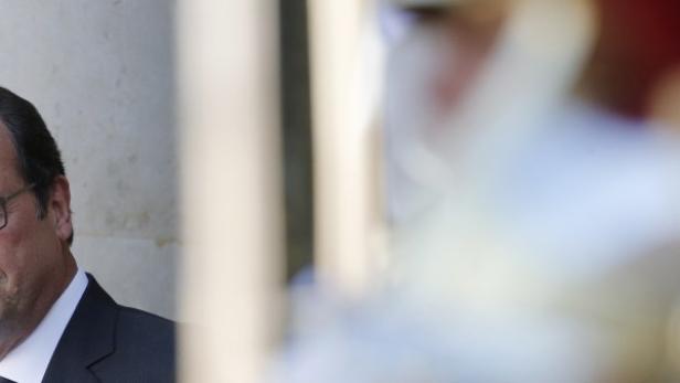 French President Hollande looks on as he stands on