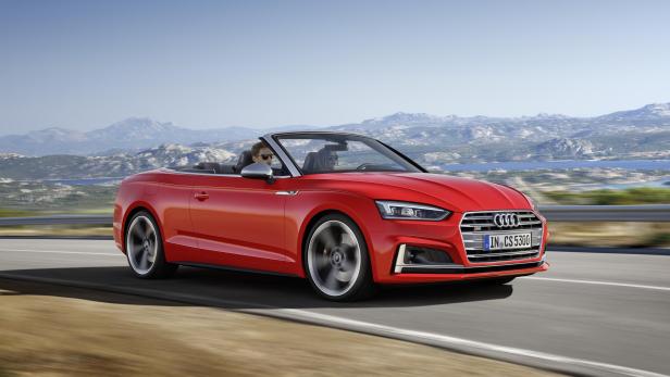 Ein rotes Audi A5 Cabriolet fährt auf einer Küstenstraße.
