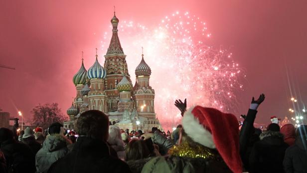 epa03521239 Thousands of locals residents gather to see the fireworks display and to see in the New Year at the Red Square in Moscow, Russia, 01 January 2013. EPA/MAXIM SHIPENKOV