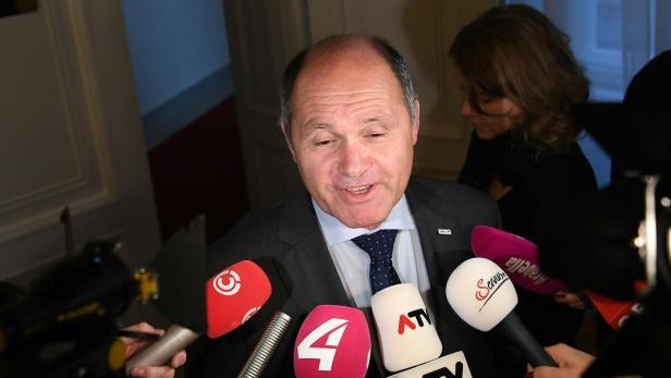 Ein Mann spricht in mehrere Mikrofone verschiedener Fernsehsender.