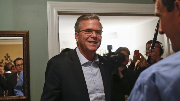 Jeb Bush lächelt in die Kamera, umgeben von Reportern und Kameras.