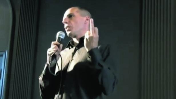 Ein Mann mit Mikrofon gestikuliert mit dem Mittelfinger.