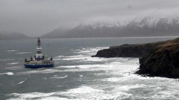 The conical drilling unit Kulluk, owned by Royal Dutch/Shell, sits aground 40 miles (64 kms) southwest of Kodiak City, Alaska, on the shore of Sitkalidak Island in this U.S. Coast Guard handout photo taken January 2, 2013. The Kulluk ran aground on New Year&#039;s Eve in &quot;near hurricane&quot; conditions and dragged two vessels trying to control it more than 10 miles toward Sitkalidak Island before the crews cut it loose to save themselves, the U.S. Coast Guard said. REUTERS/U.S. Coast Guard/Petty Officer 1st Class Travis Marsh/Handout (UNITED STATES - Tags: DISASTER ENVIRONMENT) THIS IMAGE HAS BEEN SUPPLIED BY A THIRD PARTY. IT IS DISTRIBUTED, EXACTLY AS RECEIVED BY REUTERS, AS A SERVICE TO CLIENTS. FOR EDITORIAL USE ONLY. NOT FOR SALE FOR MARKETING OR ADVERTISING CAMPAIGNS