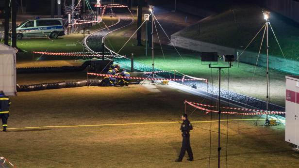 Einsatzkräfte des THW arbeiten nachts an einem Tatort, der mit Flatterband abgesperrt ist.