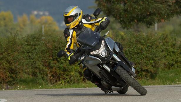 Ein Motorradfahrer fährt mit einer Honda auf einer kurvigen Straße.
