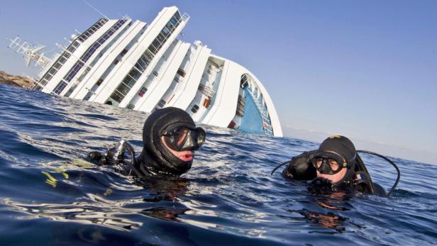 epa03467851 YEARENDER 2012 JANUARY Divers of the Italian paramilitary Carabinieri police are in the water close to the wrecked &#039;Costa Concordia&#039; cruise ship off the coaft of Giglio Island, Italy, 18 January 2012. A magistrate in Italy has said she ordered the house arrest of the cruise ship&#039;s captain because there exists the risk that he may repeat his &#039;criminal conduct,&#039; media reported on 18 January. EPA/MASSIMO PERCOSSI