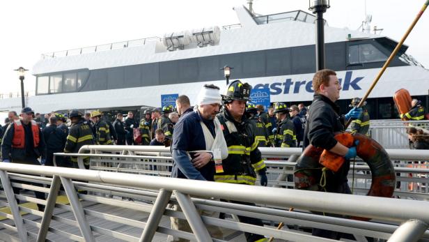 epa03528916 Patients are treated by emergency personnel on a dock after a commuter boat reportedly hit a pier while docking at the South Street Seaport in New York, New York, USA, 09 January 2013. According to media reports at least 17 people were injured. EPA/JUSTIN LANE