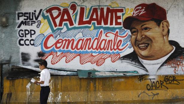 A child walks past a mural depicting Venezuela&#039;s President Hugo Chavez in Caracas January 8, 2013. Venezuela&#039;s opposition has accused the government of violating the constitution by proposing to delay cancer-stricken President Chavez&#039;s inauguration Thursday for a new term amid growing uncertainty over the polarized OPEC nation&#039;s political future. The mural reads, &quot;Go ahead commandant&quot;. REUTERS/Carlos Garcia Rawlins (VENEZUELA - Tags: POLITICS HEALTH)