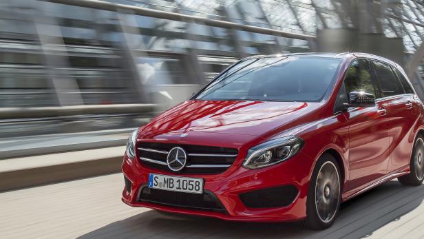 Ein roter Mercedes-Benz fährt über eine Brücke.