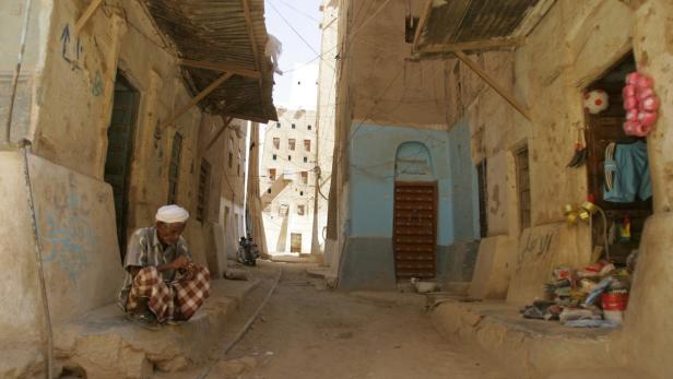 An elderly man sits outside a shop in the historical city of Shibam in southeastern Yemen March 19, 2009. Shibam, a UNESCO World Heritage site, is dubbed the &quot;Manhattan of the desert&quot; for its 16th-century tower houses. REUTERS/Khaled Abdullah (YEMEN TRAVEL)