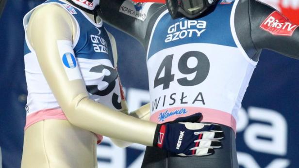 Zwei Skispringer umarmen sich und feiern einen Erfolg in Wisła.