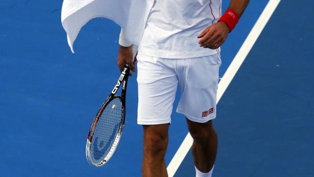 Ein Tennisspieler mit einem Schläger auf einem blauen Platz.