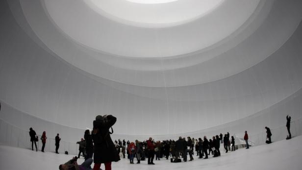 Besucher stehen in einer großen, weißen Kuppel und schauen nach oben.