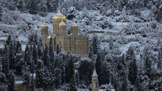 Eine russisch-orthodoxe Kirche mit goldenen Kuppeln unter einer Schneedecke.