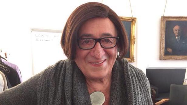 Eine Frau mit brauner Bob-Frisur und Brille lächelt in die Kamera.
