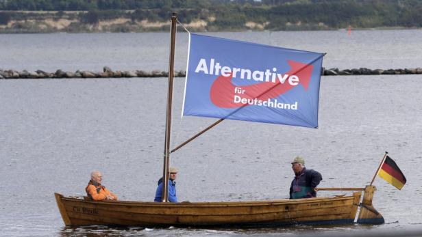 Supporters of AfD sail a boat next to square where