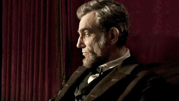Daniel Day-Lewis als Abraham Lincoln vor einem roten Vorhang.