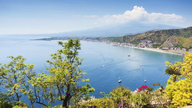 Blick auf die Küste von Taormina, Sizilien, mit dem Ätna im Hintergrund.