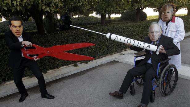 Eine politische Karikatur mit überdimensionalen Requisiten und Masken von Politikern.