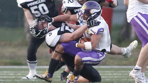 Zwei American-Football-Spieler kämpfen um den Ball.