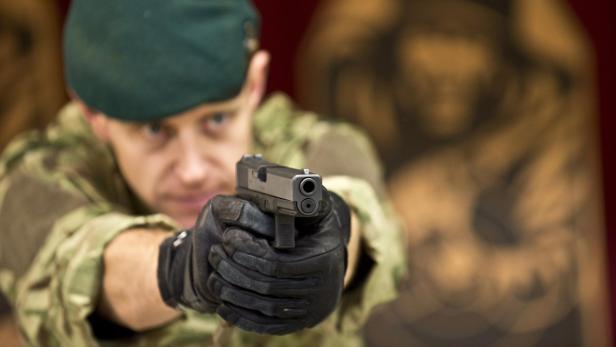 Sergeant Steve Lord from the Royal Marine Training School, Lymstone demonstrates the British military&#039;s new Glock pistol at Woolwich Barracks in London January 9, 2013. Britain&#039;s Ministry of Defence has signed a £9 million contract to provide its armed forces with more than 25,000 new Glock sidearms, which replace the Browning in use for more than 40 years. Picture taken January 9, 2013. REUTERS/Andrew Linnet/MoD/Crown Copyright/Handout (BRITAIN - Tags: POLITICS MILITARY) NO SALES. NO ARCHIVES. ATTENTION EDITORS  THIS IMAGE WAS PROVIDED BY A THIRD PARTY. FOR EDITORIAL USE ONLY. NOT FOR SALE FOR MARKETING OR ADVERTISING CAMPAIGNS. THIS PICTURE IS DISTRIBUTED EXACTLY AS RECEIVED BY REUTERS, AS A SERVICE TO CLIENTS