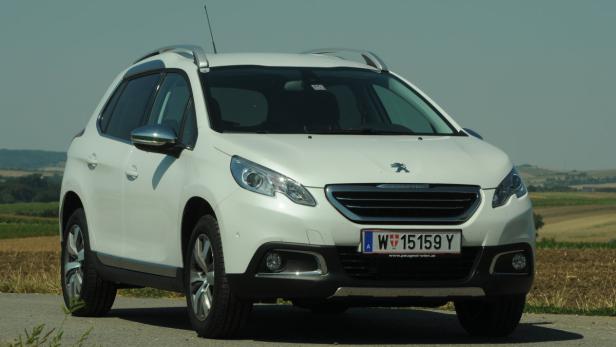 Ein weißer Peugeot 2008 steht auf einer Landstraße.