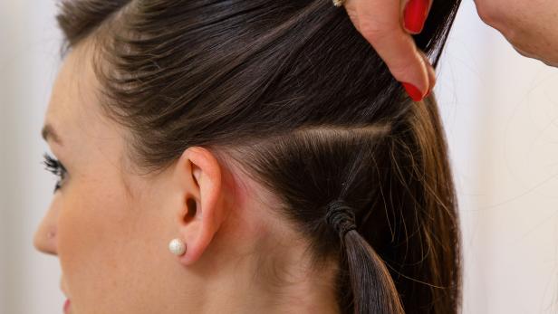Eine Frau bekommt eine Hochsteckfrisur gemacht.