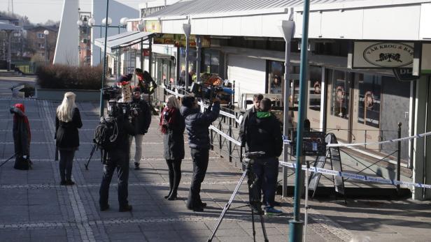 Ein Kamerateam filmt vor einem mit Polizeiabsperrband abgesperrten Restaurant.