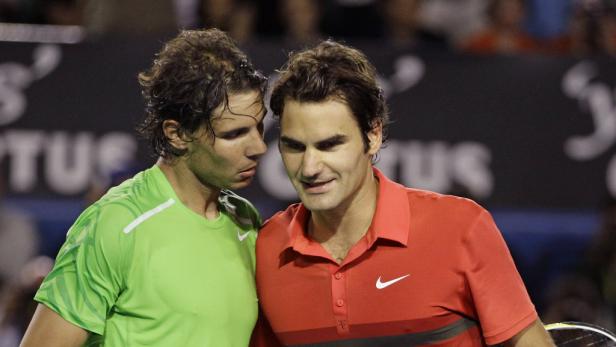 Roger Federer und Rafael Nadal stehen nebeneinander auf einem Tennisplatz.