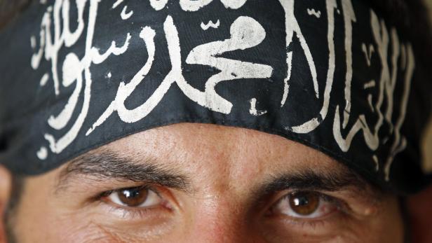 A Free Syrian Army fighter wears a headband reading the Islamic declaration of faith, &quot;There is no God but God, and Mohammed is His Messenger&quot;, in central Aleppo August 9, 2012. REUTERS/Goran Tomasevic (SYRIA - Tags: CIVIL UNREST TPX IMAGES OF THE DAY)