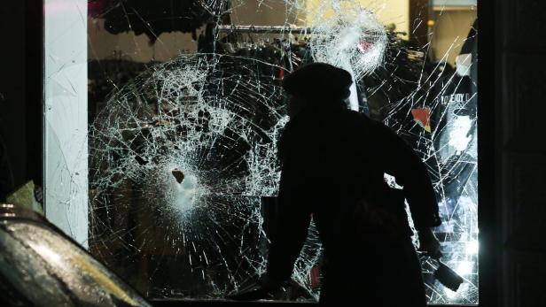 Ein Schaufenster ist durch Vandalismus beschädigt und weist ein großes Loch auf.