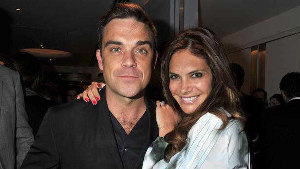 Robbie Williams posiert mit seiner Frau Ayda Field für ein Foto.