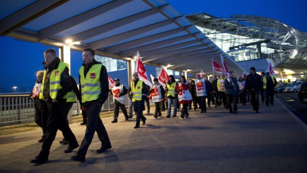 epa03625191 Security workers at Duesseldorf airport take action at the airport in Duesseldorf, Germany on 15 March 2013 over their demand for improved wages. Reports state that flights are delayed and there have been cancellations at Germanyís third largest airport. The Verdi union is looking for a pay increase of up to 30 per cent for the private security workers. EPA/DANIEL NAUPOLD