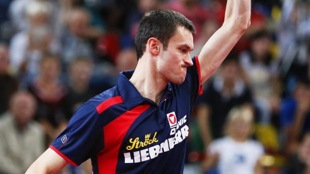 Ein Tischtennisspieler jubelt mit erhobenem Arm.