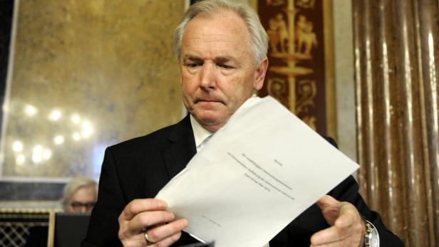 Ein Mann im Anzug liest ein Dokument.