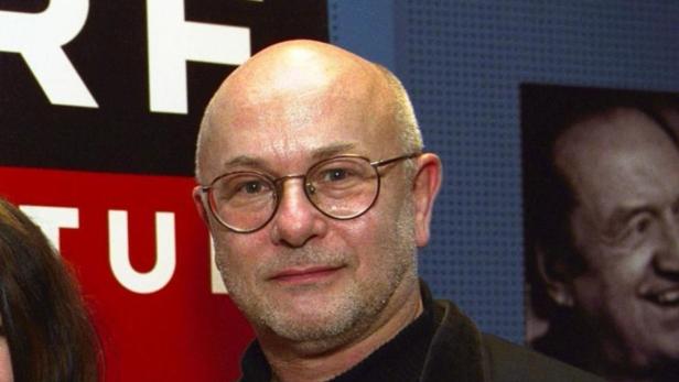 Ein Mann mit Brille und Glatze lächelt in die Kamera.