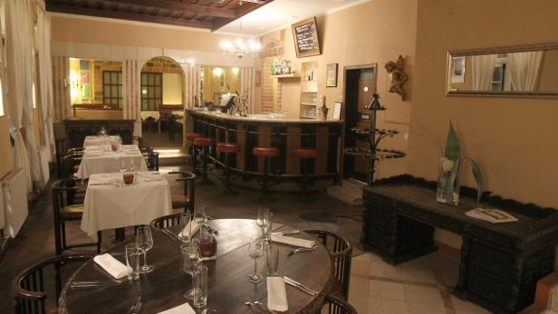 Ein einladendes Restaurant mit gedeckten Tischen und einer Bar im Hintergrund.